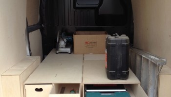 Inside the back of a van showing floor drawers, two of which are open